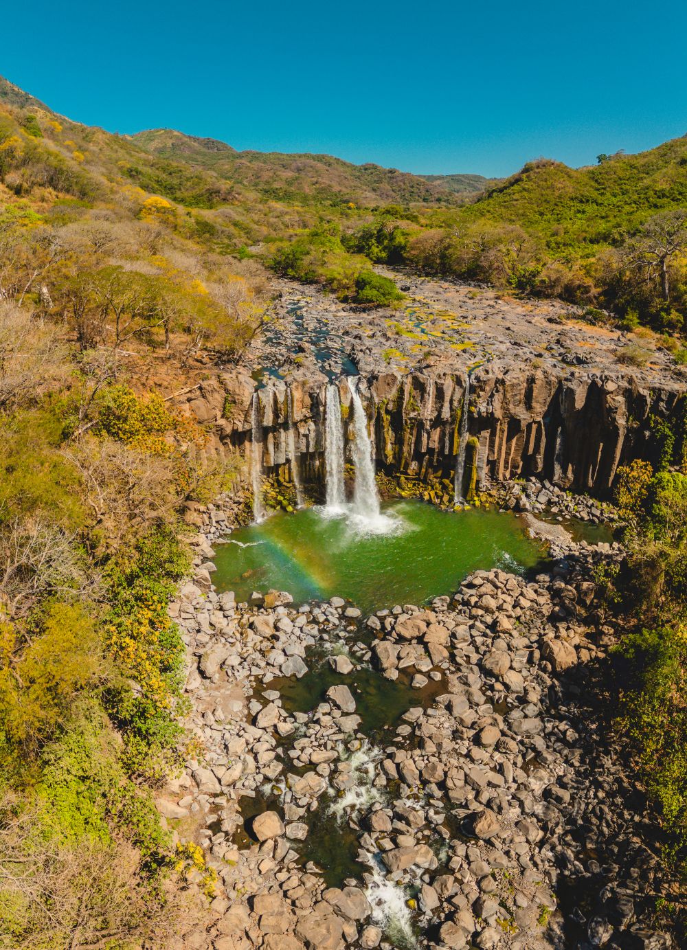 Vista aérea de las Cataratas de Los Amates en Guatemala, mostrando su forma de herradura y el salto escalonado en medio de la selva tropical