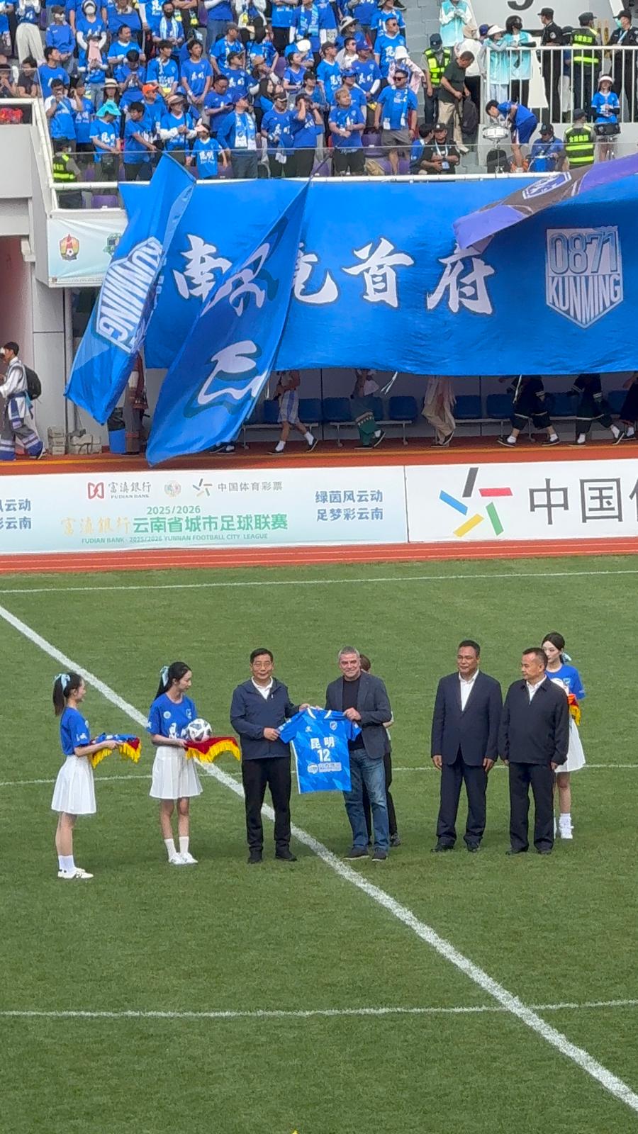 Manolo Sanchís realizando el saque de honor en un partido de fútbol en Kunming. Yunnan.